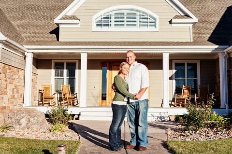 Embracing couple in front of a home.