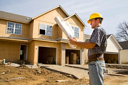 Construction worker in front of home under construction.