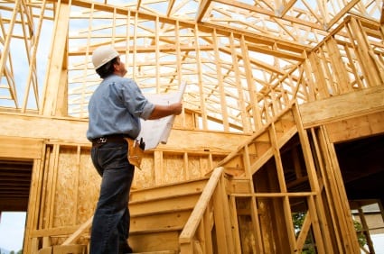 Construction worker standing in home under construction.