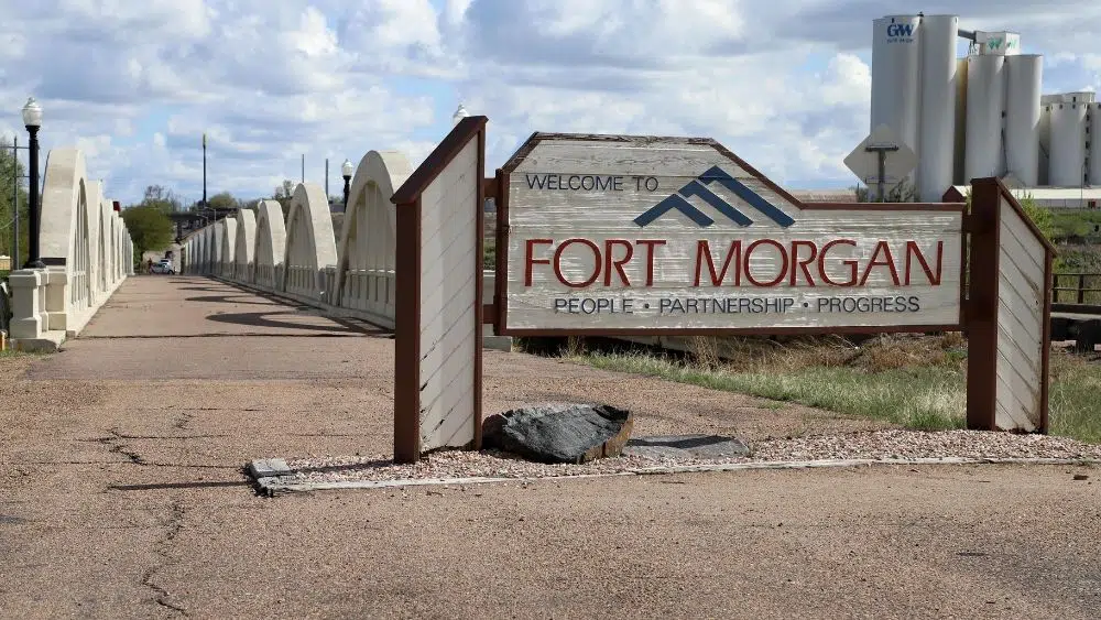 señal de tráfico que dice Fort Morgany debajo dice "personas, asociación, progreso"