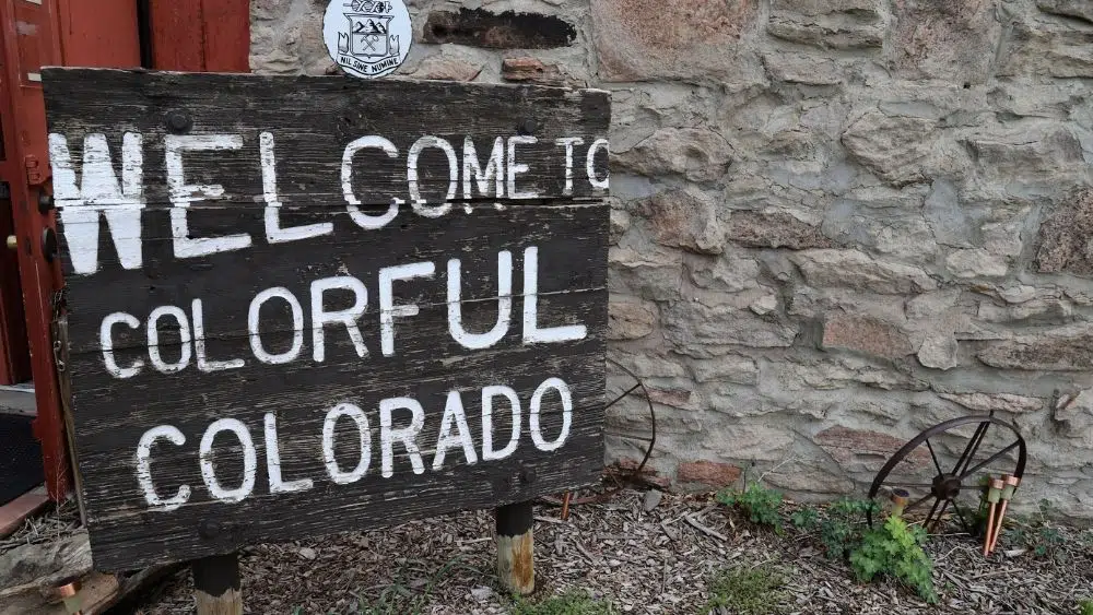 Letrero de madera que dice "Bienvenidos a Colorful Colorado"