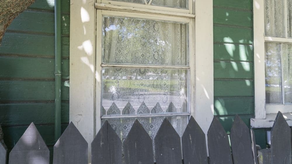 Primer plano de una casa verde con ventanas dobles
