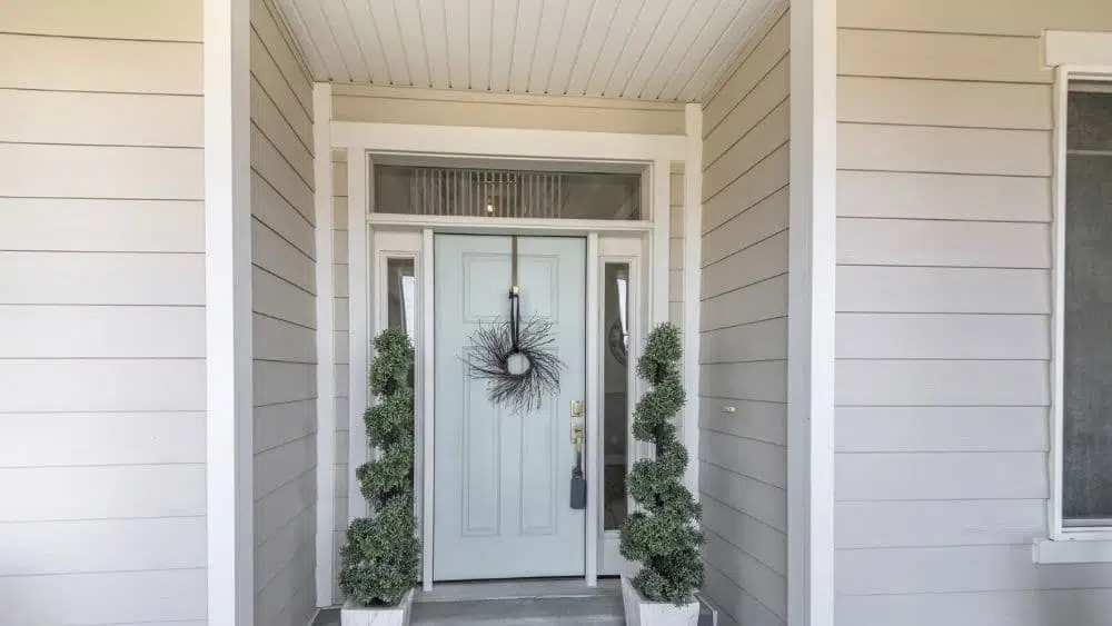 Una puerta de entrada con una ventana tramor y dos paneles laterales