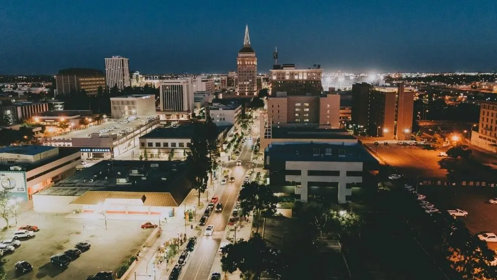 El centro de Fresno por la noche, iluminado con luces de edificios y farolas.
