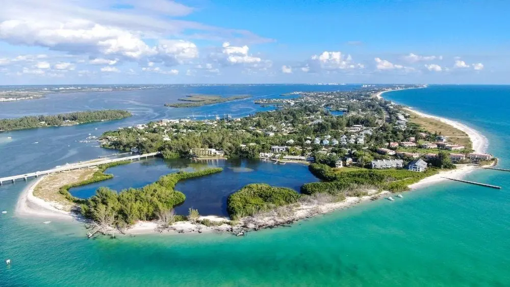 Vista aérea de Longboat Key, una isla frente a la costa de Florida con muchos árboles y algunos lagos.